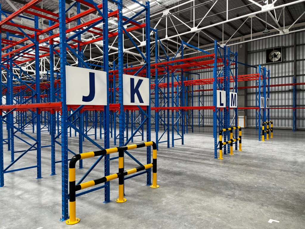 A stock photo of pallet racking protected by collision guards for article on warehouse racking.