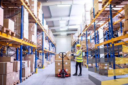 A woman working with a forklift to illustrate the importance of safety standards in warehouses.