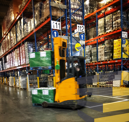 A forklift in a storage facility with warehouse signage clearly visible.