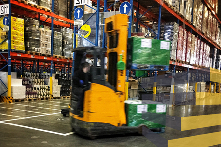Forklift moving in warehouse to illustrate importance of warehouse floor line painting. By Bernd Dittrich on Unsplash