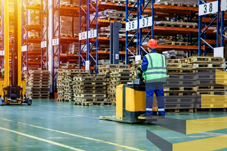 Man operating mobile workstation to illustrate article on warehouse signage in Brazil