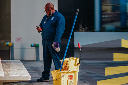 Man pausing during cleaning to illustrate article on industrial cleaning service. By Jon Tyson on Unsplash.